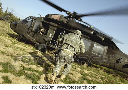 U. S. Army Soldiers prepare to board a UH-60 Black Hawk helicopter. View Large Photo Image Picture - U. S. Army Soldiers prepare to board a UH-60 Black Hawk helicopter.. Fotosearch