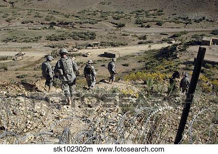 Picture - U. S Army Soldiers walk back to their humvee from a border checkpoint.. Fotosearch