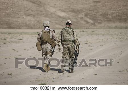 Picture - U. S. Marine and German soldier walk in a wadi near Kunduz, Afghanistan.. Fotosearch