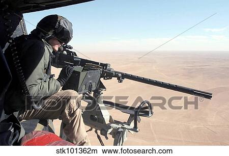 U. S. Marine checks out the GAU-16/A Cal. 50 machine gun onboard his UH-1N Huey helicopter. View Large Photo Image Picture - U. S. Marine checks out the GAU-16/A Cal. 50 machine gun onboard his UH-1N Huey helicopter.. Fotosearch