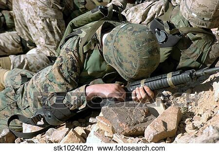 U. S. Marine Corps Private takes cover, protecting his 5. 56 mm M16A2 rifle. View Large Photo Image Picture - U. S. Marine Corps Private takes cover, protecting his 5. 56 mm M16A2 rifle.. Fotosearch