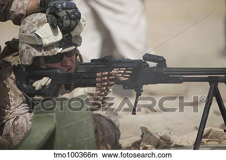 Picture - U. S. Marine firing a PK 7. 62mm machine gun.. Fotosearch