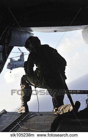 U. S. Marine looks out the back of a CH-46E Sea Knight. View Large Photo Image Picture - U. S. Marine looks out the back of a CH-46E Sea Knight.. Fotosearch