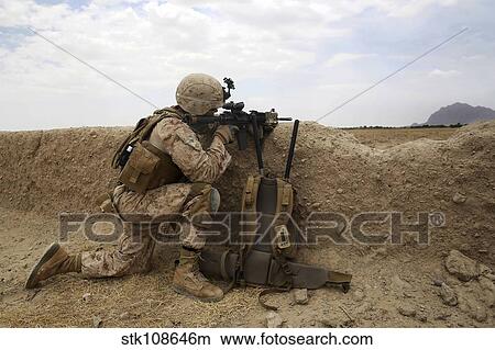 U. S. Marine provides security from behind a mud wall. View Large Photo Image Picture - U. S. Marine provides security from behind a mud wall.. Fotosearch