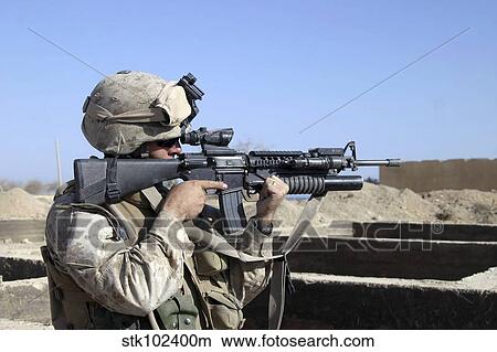 U. S. Marine sites through the scope atop his 5. 56mm M16A2 rifle while providing security. View Large Photo Image Picture - U. S. Marine sites through the scope atop his 5. 56mm M16A2 rifle while providing security.. Fotosearch