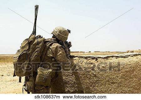 U. S. Marine takes cover behind a wall during a patrol in Afghanistan. View Large Photo Image Picture - U. S. Marine takes cover behind a wall during a patrol in Afghanistan.. Fotosearch