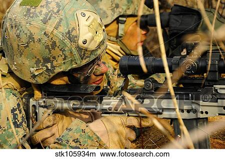 Picture - U. S. Marine uses a spotting scope to help fellow Marine identify a target.. Fotosearch