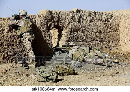 Picture - U. S. Marines take cover during a patrol in Afghanistan.. Fotosearch