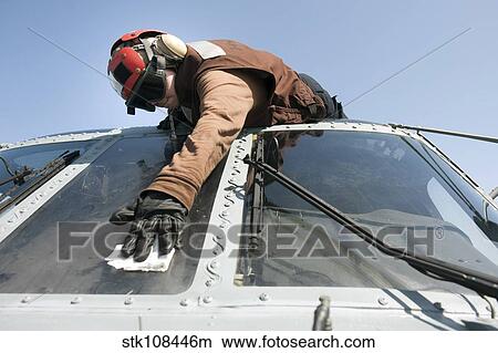 U. S. Navy Airman cleans the windshield of an MH-60R Seahawk. View Large Photo Image Picture - U. S. Navy Airman cleans the windshield of an MH-60R Seahawk.. Fotosearch