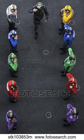 U. S. Navy commander salutes as he passes through an honor guard of flight deck crewmembers. View Large Photo Image Picture - U. S. Navy commander salutes as he passes through an honor guard of flight deck crewmembers.. Fotosearch