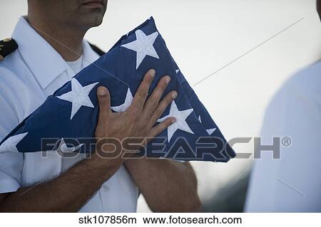 U. S. Navy commanding officer holds the national ensign. View Large Photo Image Picture - U. S. Navy commanding officer holds the national ensign.. Fotosearch