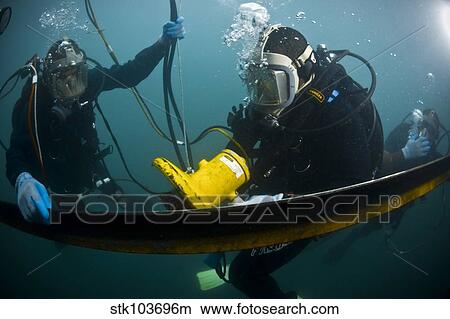 U. S. Navy Diver instructs a Barbados coast guard diver on using a hydraulic grinder underwater. View Large Photo Image Picture - U. S. Navy Diver instructs a Barbados coast guard diver on using a hydraulic grinder underwater.. Fotosearch