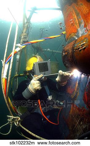 U. S. Navy Diver welds a repair patch on the submerged bow of the USS Ogden. View Large Photo Image Picture - U. S. Navy Diver welds a repair patch on the submerged bow of the USS Ogden.. Fotosearch