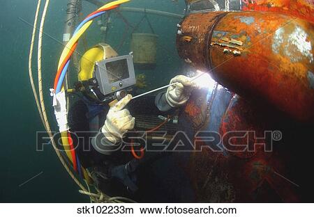 U. S. Navy Diver welds a repair patch on the submerged bow of the USS Ogden. View Large Photo Image Picture - U. S. Navy Diver welds a repair patch on the submerged bow of the USS Ogden.. Fotosearch