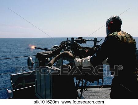 U. S. Navy Gunner's Mate fires a Mark 38 (MK-38) 25 mm machine gun system. View Large Photo Image Picture - U. S. Navy Gunner's Mate fires a Mark 38 (MK-38) 25 mm machine gun system.. Fotosearch