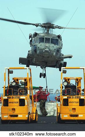 U. S. Navy Sailors attach a sling to the belly of an HH-60H Seahawk helicopter. View Large Photo Image Picture - U. S. Navy Sailors attach a sling to the belly of an HH-60H Seahawk helicopter.. Fotosearch
