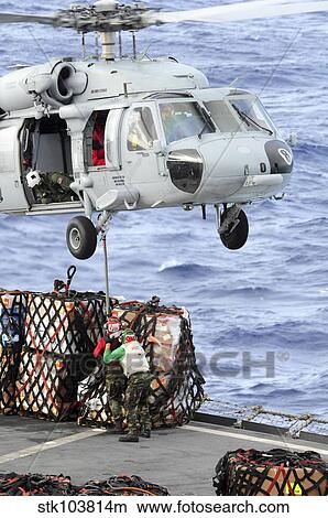 U. S. Sailors connect a cargo pendant to an MH-60S Seahawk helicopter. View Large Photo Image Picture - U. S. Sailors connect a cargo pendant to an MH-60S Seahawk helicopter.. Fotosearch