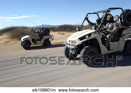 U. S. Soldiers drive multiple LTATV's down a dirt road. View Large Photo Image Picture - U. S. Soldiers drive multiple LTATV's down a dirt road.. Fotosearch