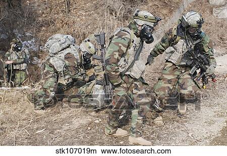 U. S. Soldiers wear gas masks as they extract a soldier during training. View Large Photo Image Picture - U. S. Soldiers wear gas masks as they extract a soldier during training.. Fotosearch