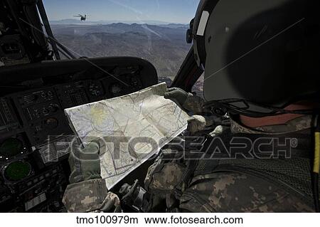 UH-60 Black Hawk pilot reading a map while in flight to New Mexico. View Large Photo Image Picture - UH-60 Black Hawk pilot reading a map while in flight to New Mexico.. Fotosearch