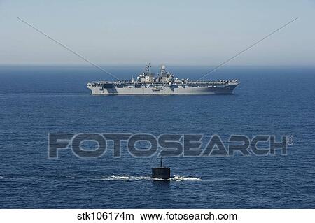 Picture - USS Hampton transits alongside USS Makin Island.. Fotosearch