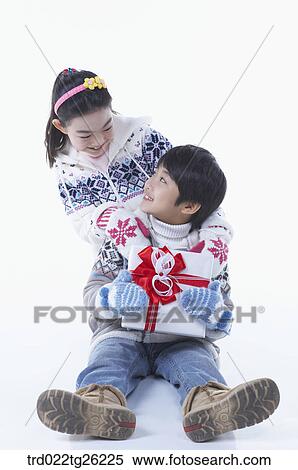 Stock Illustration - boy and girl got christmas present. Fotosearch