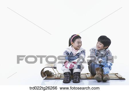 Stock Illustration - girl and boy sitting on the sled. Fotosearch