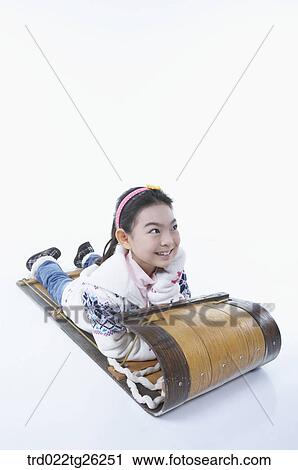 Clip Art - girl laying on stomach on the sled. Fotosearch