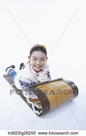 Clipart - girl laying on stomach on the sled. Fotosearch