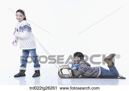 Clip Art - girl pulling the sled and boy laying on stomach. Fotosearch