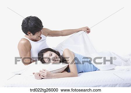 Clipart - woman and guy relaxed on the bed. Fotosearch