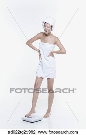 woman in a towel measuring her weight View Large Illustration Drawing - woman in a towel measuring her weight. Fotosearch