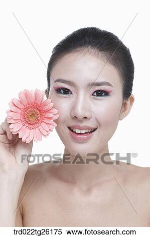 Stock Illustration - woman wearing makeup and holding blossom. Fotosearch