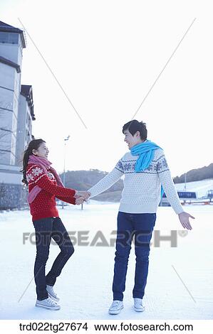 cordial couple holding hands in same clothing View Large Photo Image Picture - cordial couple holding hands in same clothing. Fotosearch
