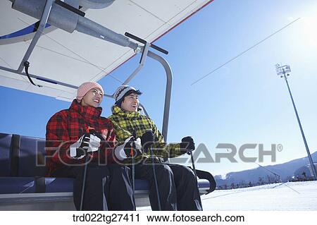 Stock Image - couple smile on ski lift. Fotosearch
