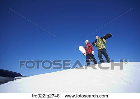 couple standing on the snow hill with a snow board View Large Photo Image Stock Image - couple standing on the snow hill with a snow board. Fotosearch