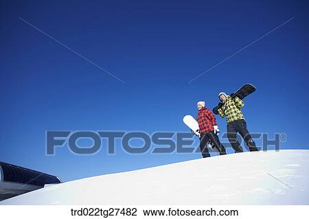 couple standing on the snow hill with a snow board View Large Photo Image Stock Image - couple standing on the snow hill with a snow board. Fotosearch
