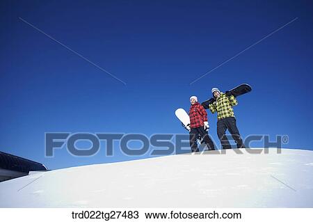 couple standing on the snow hill with a snow board View Large Photo Image Stock Image - couple standing on the snow hill with a snow board. Fotosearch