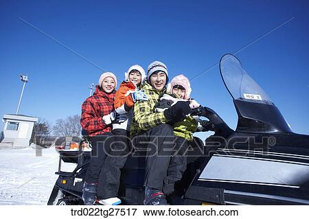 Stock Photo - family riding a motor ski vehicle. Fotosearch