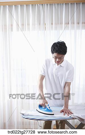 Stock Photo - man ironing his shirt. Fotosearch