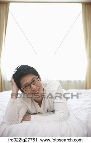 man lying down the bed View Large Photo Image Stock Image - man lying down the bed. Fotosearch