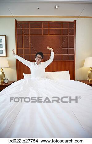 Picture - man waking up on the bed. Fotosearch