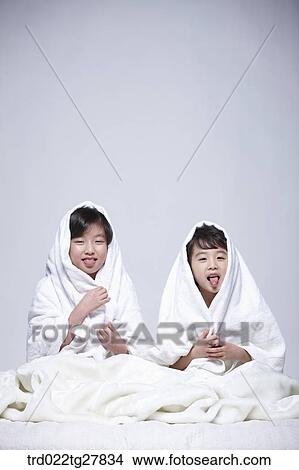 Picture - children education boy and girl covered themselves with a blanket. Fotosearch