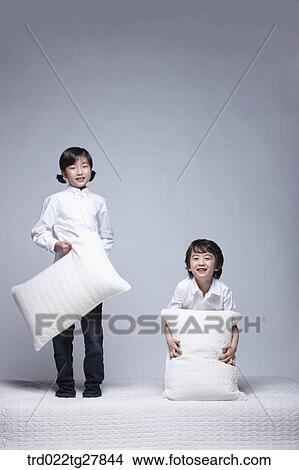children education boy and girl holding pillows on the bed View Large Photo Image Picture - children education boy and girl holding pillows on the bed. Fotosearch