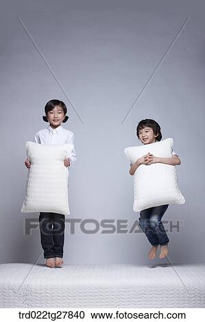 children education boy and girl holding pillows on the bed View Large Photo Image Stock Image - children education boy and girl holding pillows on the bed. Fotosearch