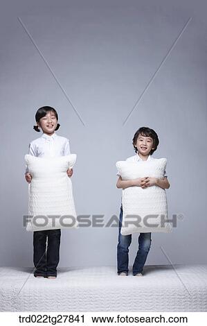 children education boy and girl holding pillows on the bed View Large Photo Image Stock Image - children education boy and girl holding pillows on the bed. Fotosearch