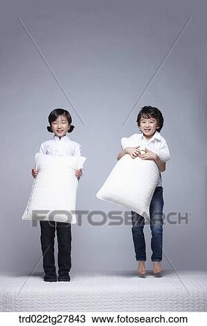 children education boy and girl holding pillows on the bed View Large Photo Image Stock Image - children education boy and girl holding pillows on the bed. Fotosearch