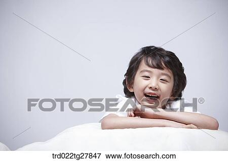 Stock Photo - children education boy lay face down on the pillow. Fotosearch