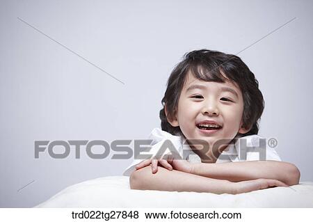 Stock Photo - children education boy lay face down on the pillow. Fotosearch