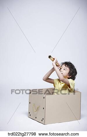 Stock Photo - children education boy look through a telescope in a box. Fotosearch